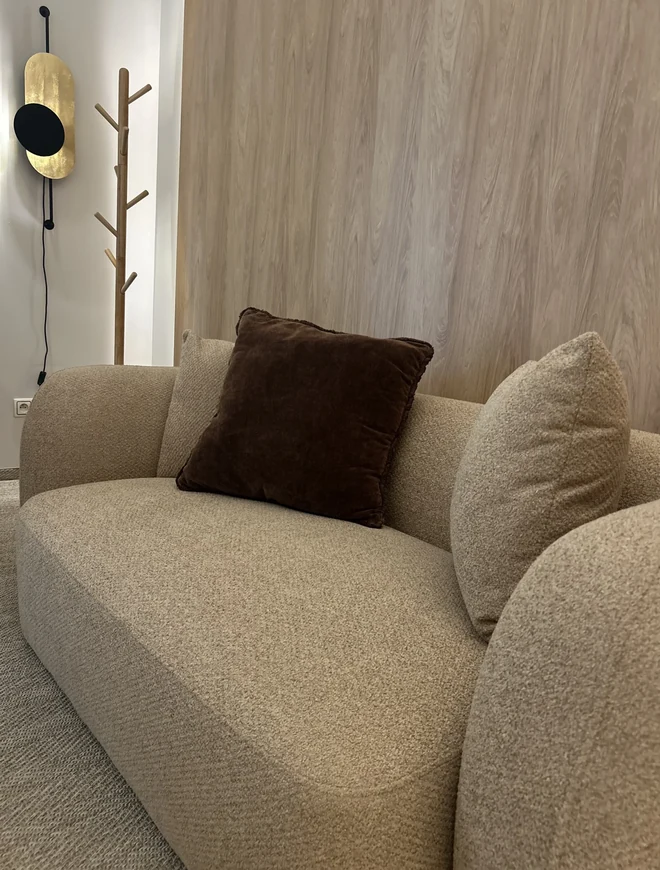 Kącik do rozmowy w gabinecie — beżowa sofa z brązową poduszką